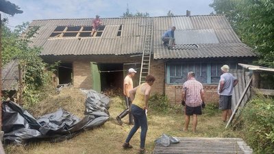 Волонтери лагодять дах, який зазнав ушкоджень внаслідок вибухової хвилі 19 серпня, 1 вересня 2023, Меджибізька громада