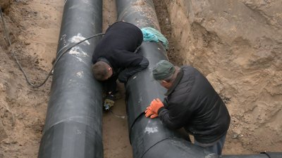 Після ремонту теплотраси у Луцьку робітники засипають розриту траншею Після ремонту теплотраси у Луцьку робітники засипають розриту траншею