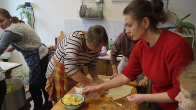 Переселенки разом з місцевими ліплять вареники Переселенки разом з місцевими ліплять вареники