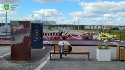 Чоловік сидить біля зруйнованого Романівського мосту
