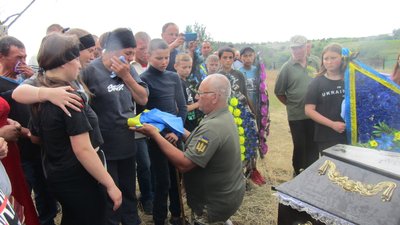 Військовий передає рідним захисника українських стяг