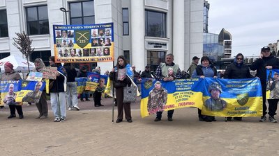 Люди тримають банери з фотографіями військових, які не повернулися з бойових завдань