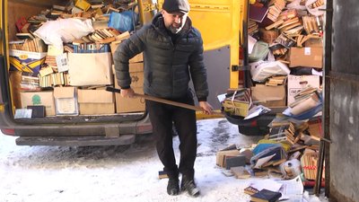 Волонтер шуфлею набирає книги Волонтер шуфлею набирає книги
