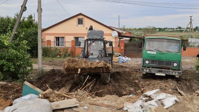 Сусід Олени Романюк допомагає жінці вивезти залишки будівлі на сміттєзвалище Сусід Олени Романюк допомагає жінці вивезти залишки будівлі на сміттєзвалище
