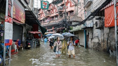 Люди пробираються крізь паводкові води в Бангкоку