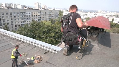 Промислові альпіністи у Харкові закривають вибиті через війну вікна Промислові альпіністи у Харкові закривають вибиті через війну вікна