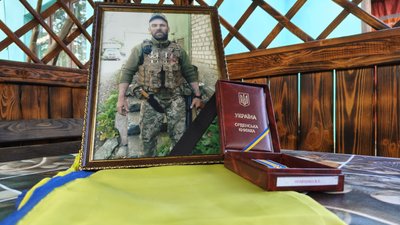 Фотографія Віталія Кравченка у рамці поруч з орденською книжкою "За мужність" ІІІ ступеня Фотографія Віталія Кравченка у рамці поруч з орденською книжкою "За мужність" ІІІ ступеня