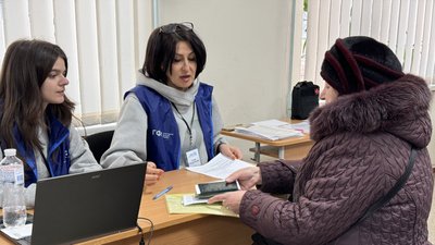 Жінка заповнюює документи на допомогу на оплату опалення від благодійників