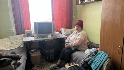 Жінка сидить на канапі в кімнаті гуртожитку