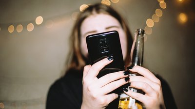 Неправдивий виклик у Чернігові: жінка з пляшкою та телефоном в руках.