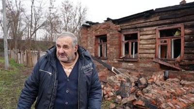 Володимир Кравцов біля зруйнованого будинку в Харкові