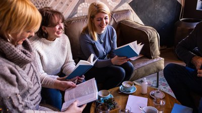Жінки чиають книжки під час чаювання Жінки чиають книжки під час чаювання