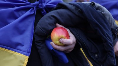Чоловік звільнений з полону під час обміну військоволоненими тримає у руках яблуко