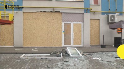Люди тимчасово закривають пошкоджені вікна й двері тирсоплитою. 19 лютого 2023 рік. Люди тимчасово закривають пошкоджені вікна й двері тирсоплитою. 19 лютого 2023 рік.