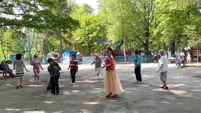 Люди танцюють у парку просто неба
