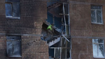 Поліцейські оглядають школу, пошкоджену внаслідок удару російського безпілотника в Києві