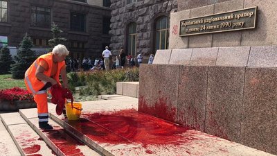 Жінка змиває фарбу біла КМДА, фото: Нацполіція Жінка змиває фарбу біла КМДА, фото: Нацполіція