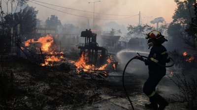 Пожежник намагається загасити пожежу недалеко від Афін, Греція, 20 липня.