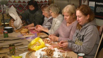Переселенці з місцевими волонтерами збираються у гуманітарному штабі Переселенці з місцевими волонтерами збираються у гуманітарному штабі