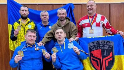 Фехтувальники тримають нагороди та прапор штурмового батальйону "Тавр"