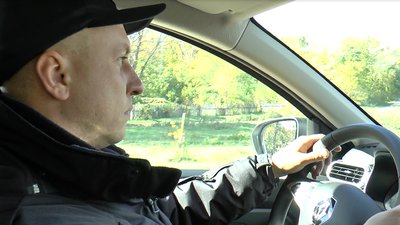 Поліцейський офіцер громади їде на автомобілі Поліцейський офіцер громади їде на автомобілі
