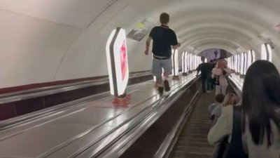 Хлопець біжить по балюстраді між ескалаторами станції метро