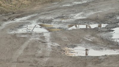 Глибокі ями, калюжі та болото - така дорога в одному із районів приватної забудови Хмельницького. Фото: Суспільне. Поділля. Глибокі ями, калюжі та болото - така дорога в одному із районів приватної забудови Хмельницького. Фото: Суспільне. Поділля.