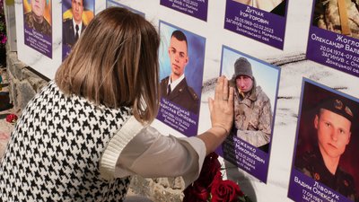 Вікторія доторкається до портрета свого чоловіка на Алеї Слави