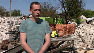 Один з друзів переселенців Станіслав Щербоп'ян на фоні цегли для будівництва будинку Один з друзів переселенців Станіслав Щербоп'ян на фоні цегли для будівництва будинку