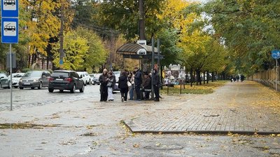 Чернівчани на одній із зупинок громадського транспорту міста під час дощу