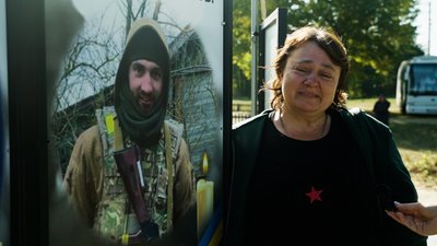 Галина Бухмій поруч з пам'ятною фотографією свого сина Юрія Ворони в Лукашівці на Чернігівщині