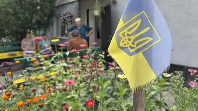 Люди сидять на лавах біля будівлі