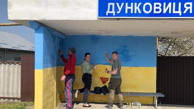 Місцеві жителі разом з переселенцями розфаровують патріотичну зупинку