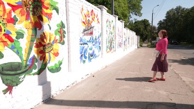 У Рівному художниця зі столиці розмальовує паркан патріотичними малюнками У Рівному художниця зі столиці розмальовує паркан патріотичними малюнками