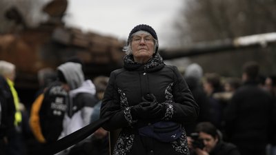 Жінка стоїть перед уламками російського танка Т-72. Берлін, Німеччина, 24 лютого 2023 р.