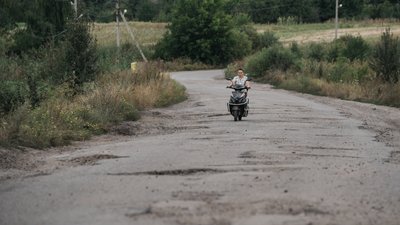 Жінка їде на скутері
