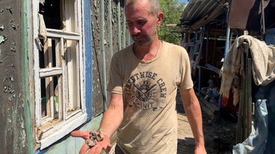 Олександр показує пошкодження після російського обстрілу