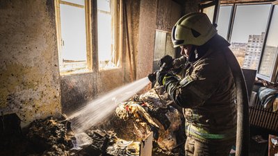Рятувальник гасить пожежу в квартирі на Салтівці у Харкові, де загинула літня жінка