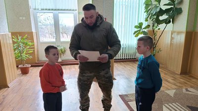 Військовослужбовець Роман вручає Демяну та Костянтину Чирукам подяку від військової бригаду Військовослужбовець Роман вручає Демяну та Костянтину Чирукам подяку від військової бригаду