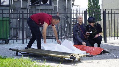 Батько читає молитву над тілом вбитого російським “Ураганом” 13-річного сина вранці 20 липня. Уламками снаряда, який влучив біля тролейбусної зупинки, також була поранена 15-річна сестра Батько читає молитву над тілом вбитого російським “Ураганом” 13-річного сина вранці 20 липня. Уламками снаряда, який влучив біля тролейбусної зупинки, також була поранена 15-річна сестра