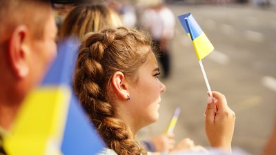 Дівчина тримає прапорець під час військогово параду на Майдані, 24 серпня 2021 Дівчина тримає прапорець під час військогово параду на Майдані, 24 серпня 2021