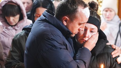 Чоловік обнімає жінку під час панахиди
