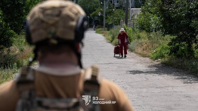 Український військовий йде дорогою поряд з місцевою жителькою у Дружківці