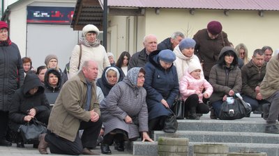Жителі громади на колінах зустрічають полеглого бійця Жителі громади на колінах зустрічають полеглого бійця