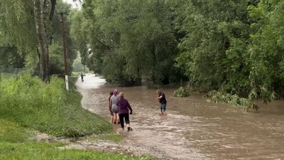 Люди переходять затоплену ділянку дороги, Хмельниччина, 11 червня 2026 року
