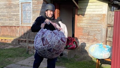 Евакуація з прикордоння Чернігівщини: поліцейський переносить майно пенсіонерки Евакуація з прикордоння Чернігівщини: поліцейський переносить майно пенсіонерки