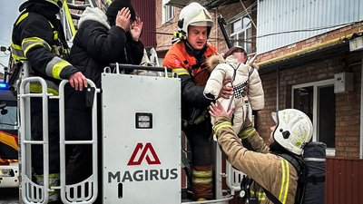 Рятувальники дістають дитину з багатоповерхівки, в який сталося загоряння