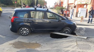 У Тернополі автомобіль провалився у яму на дорозі У Тернополі автомобіль провалився у яму на дорозі