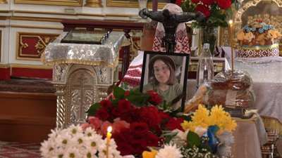 На столі у храмі фото загиблої Інни Нявкевич, хліб та квіти.