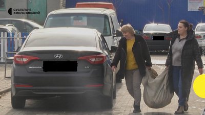 Людмила з донькою виносить скло від вікон на смітник. Людмила з донькою виносить скло від вікон на смітник.